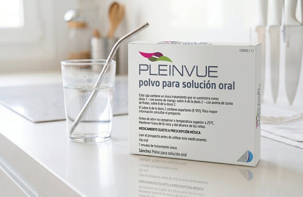 Caja de Pleinvue, polvo para solución oral, sobre la encimera de una cocina junto a un vaso de agua